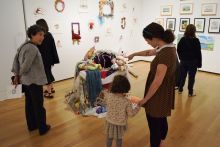 A group of people, including a child, view an exhibit at the Exhibition.