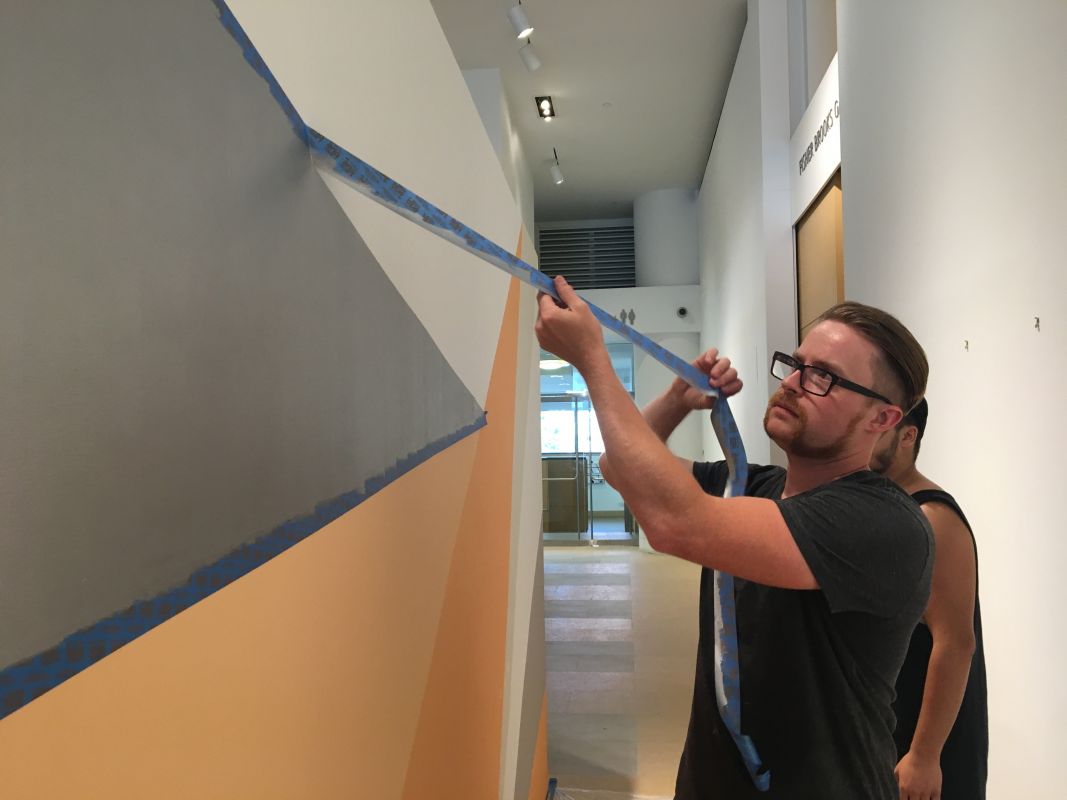 Matt Chapman (MFA '15) works on the temporary mural in the Hamilton Building.