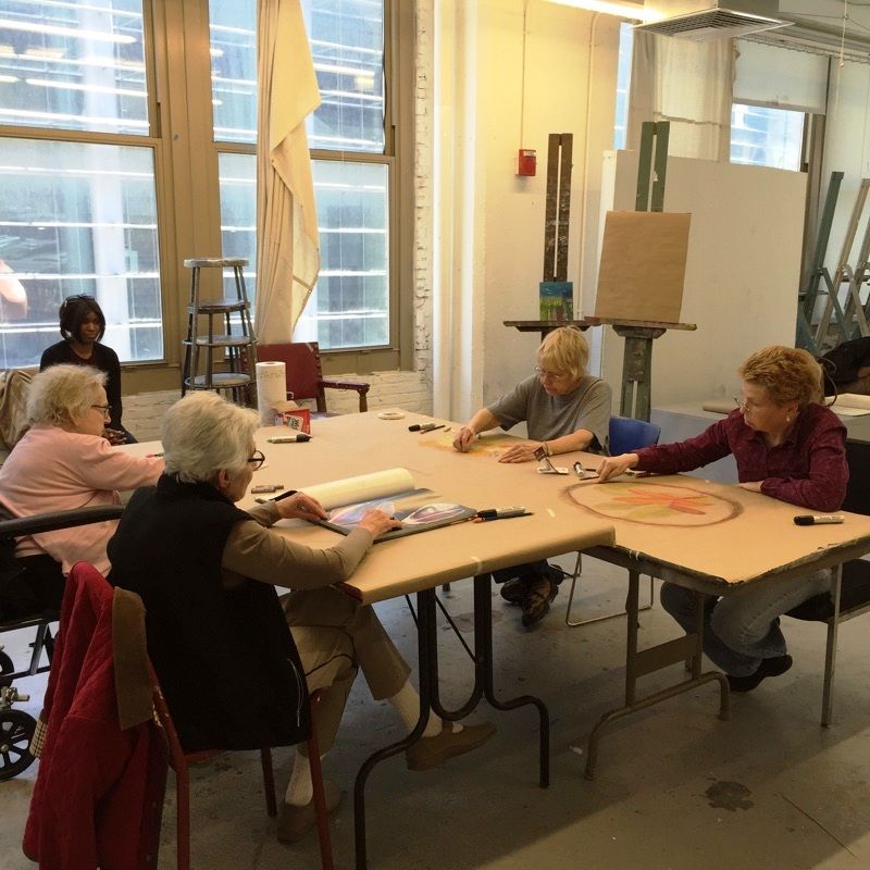Five people sitting at their desks in an art class.