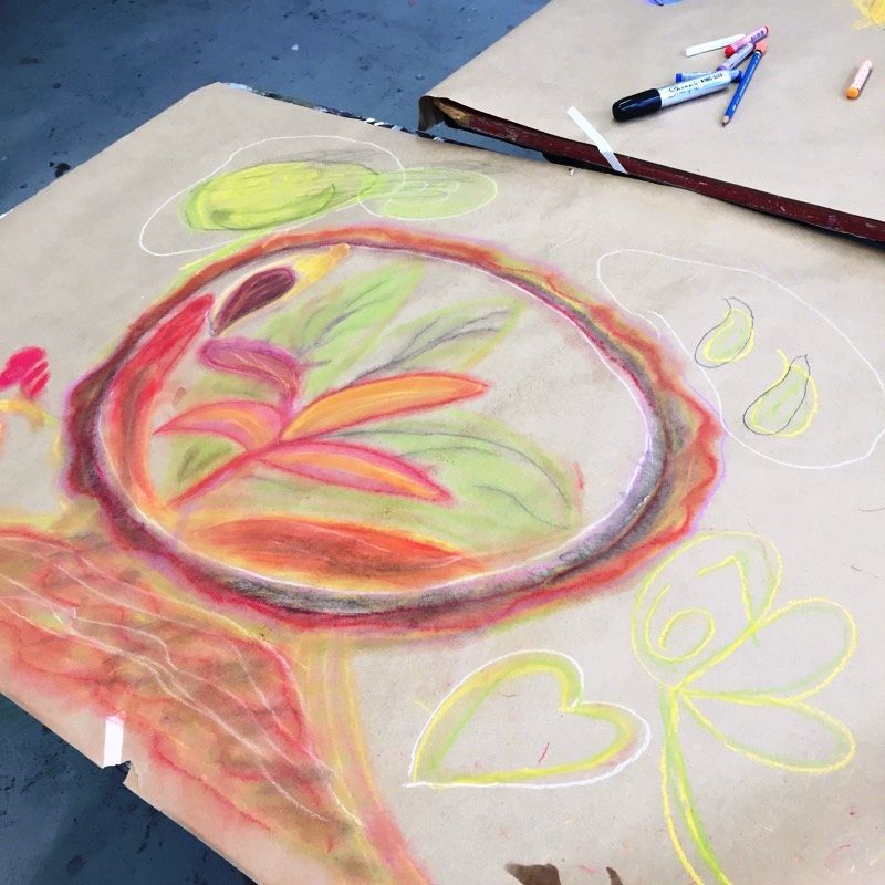 A drawing of a flower on brown paper.