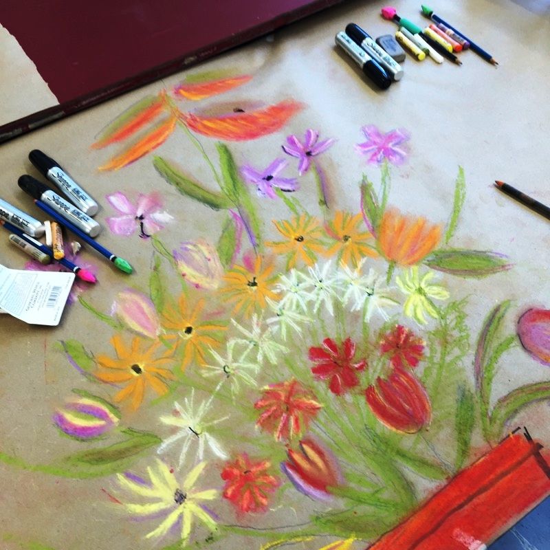 A picture of a t-shirt with a drawing and art supplies on it.