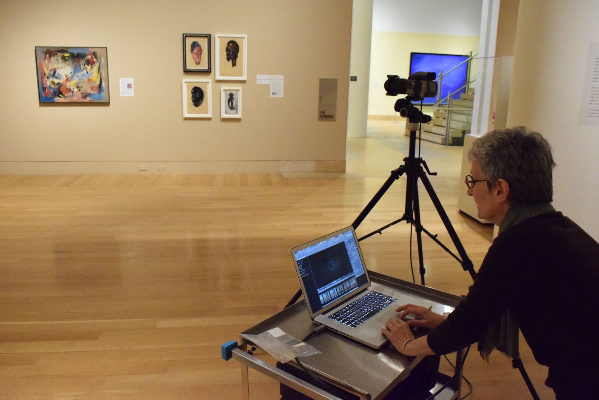 Barbara Katus, PAFA’s Manager of Imaging Services, taking installation photos of Procession: The Art of Norman Lewis.