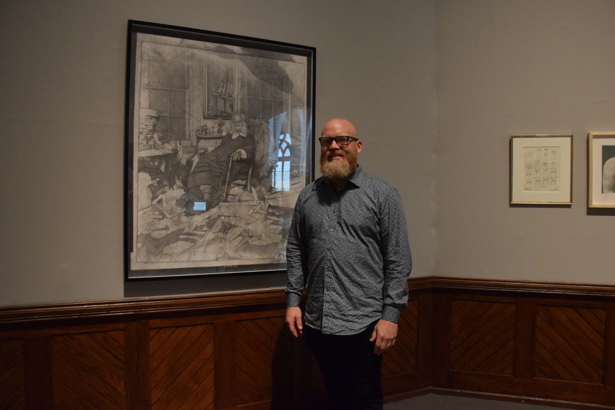 Artist Mark Stockton stands in front of his work, "The Poet in His Bedroom..." at the opening reception for the Youth Council's exhibition, "Multitudes: Whitman at 200."