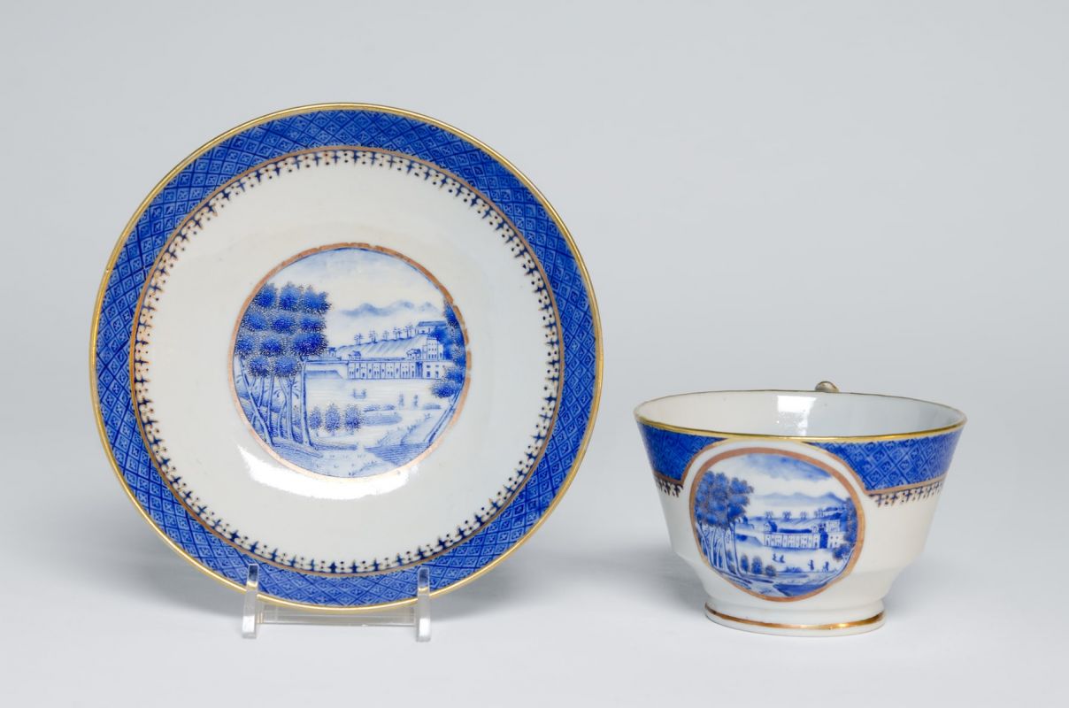 Artist/maker unknown, Chinese, for export to the American market, " Cup and saucer showing the Philadelphia Waterworks" (1825). Hard-paste porcelain with cobalt underglaze, decoration, and gilt. Cup: 2 5/8 x 4 3/8 x 3 5/8 in.; saucer: 1 1/8 x 5 1/2 in. | 