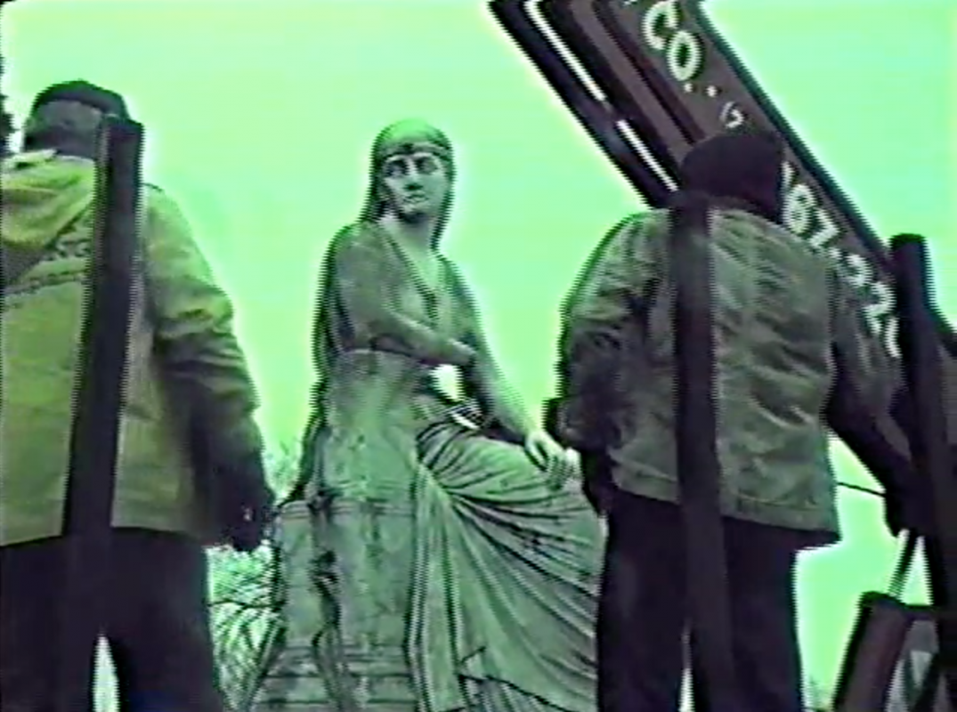 green tinted video still of statue in park 1986