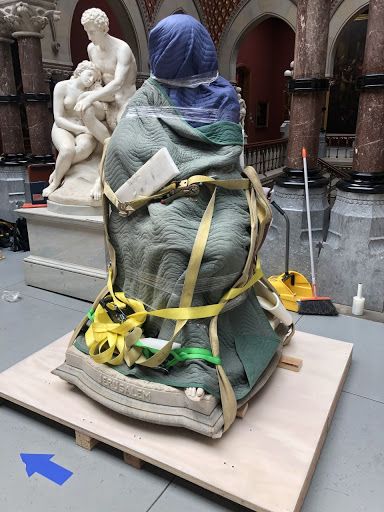 statue on palette wrapped in moving blankets