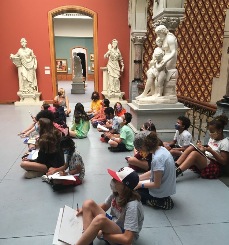 group of campers sketching in the museum 