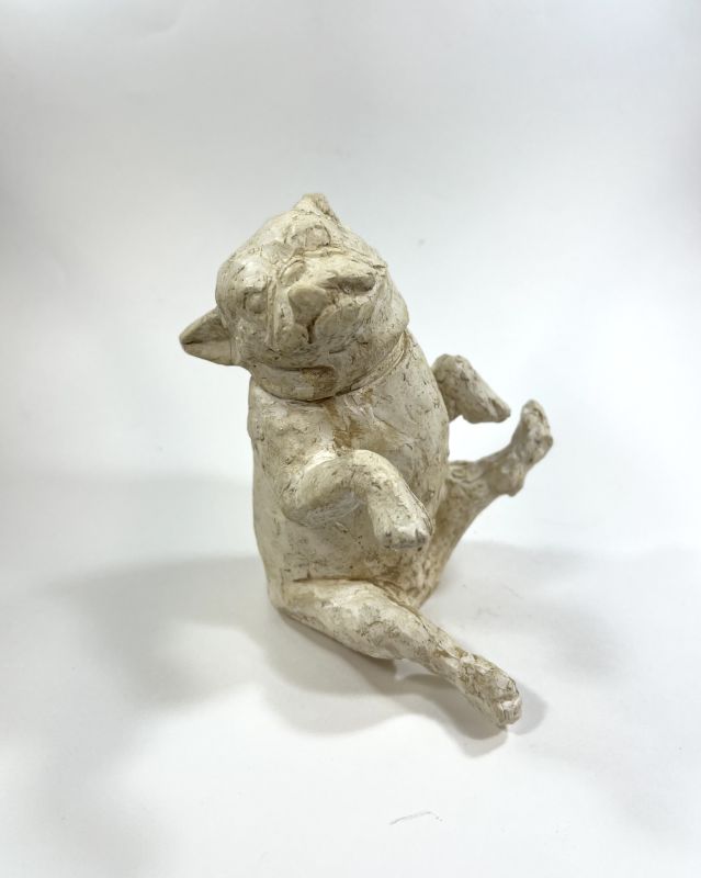 Plaster sculpture of bulldog kicking up its legs