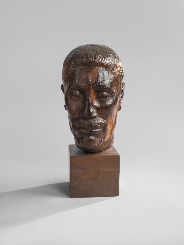 A wooden sculpture of a human head. 