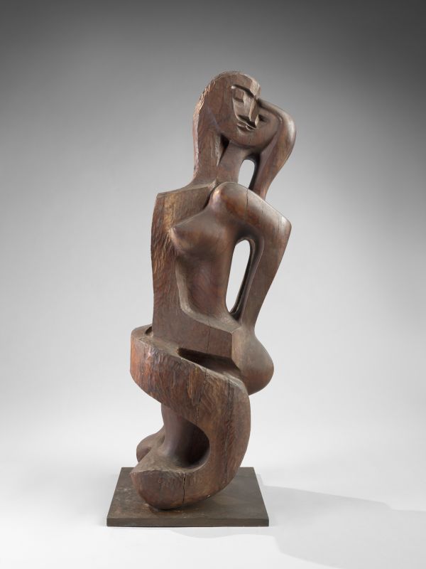 A wooden sculpture of two human figures kissing. 