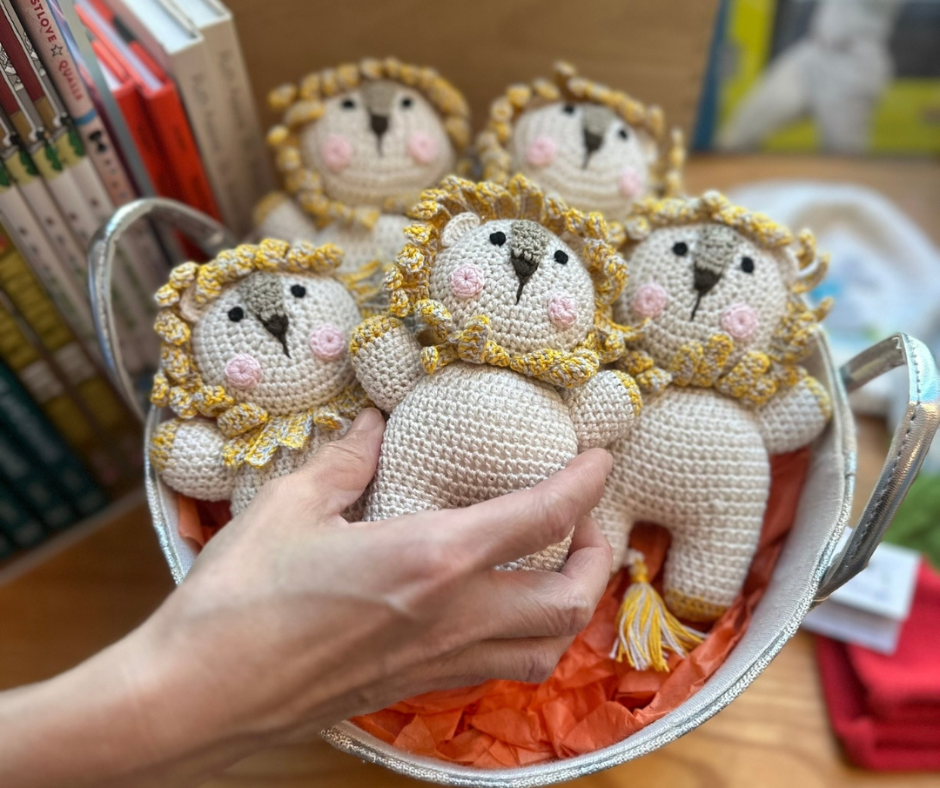 hand picking up crocheted lion