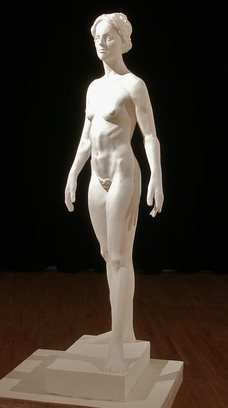 A full-length white plaster sculpture of a standing nude female figure, shown in a three-quarter view against a solid black background.