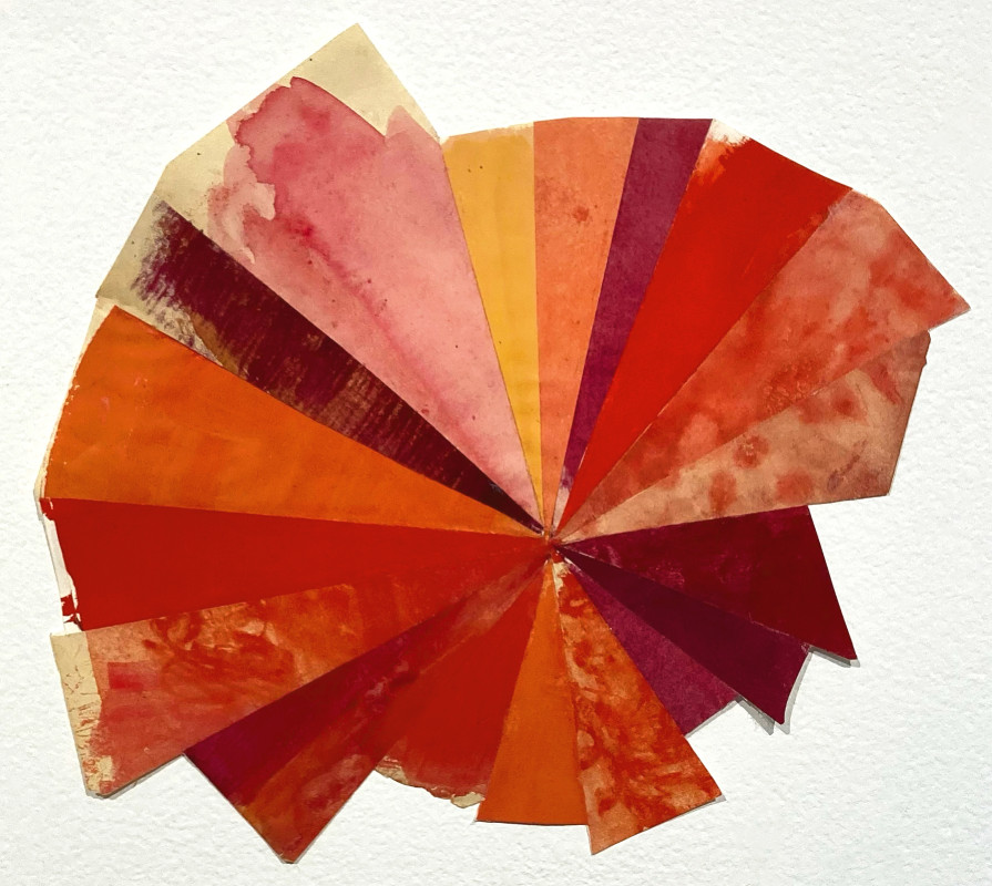 A spiral, fan-like collage made of triangular wedges of handmade paper in overlapping shades of red, orange, and pink radiation from a central point.