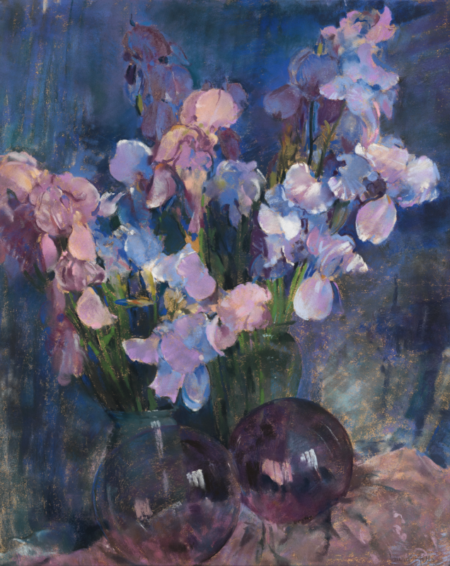 An impressionist floral still life painting featuring a lush bouquet of pink, purple, and pale blue irises in a vase, arranged behind two dark, reflective glass orbs on a textured surface against a deep blue background.