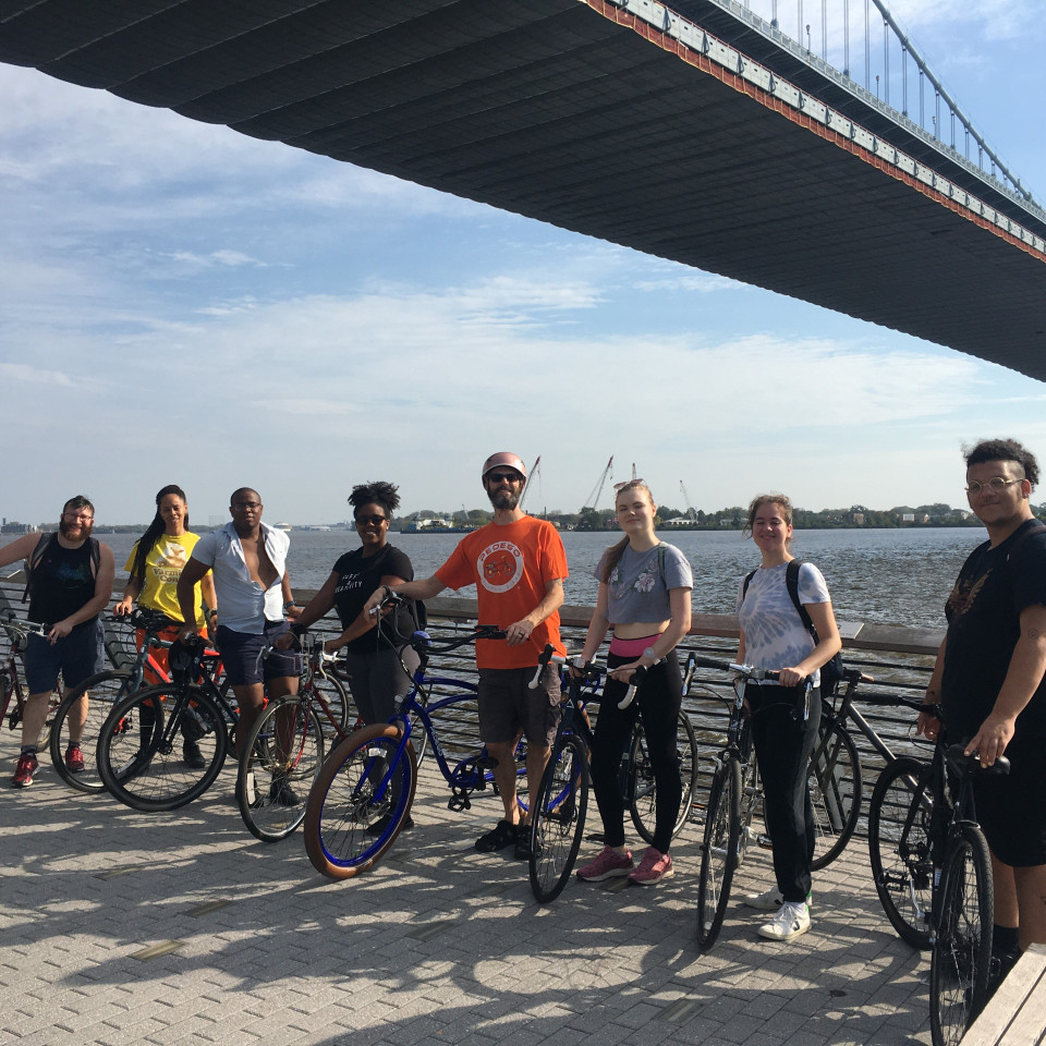 students on bikes below bridge