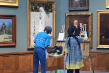 Two students painting in museum gallery