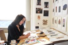 Madison Greiner paints at desk