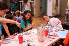 Young students at painting table smiling at camera
