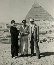 Black and white photograph of John Rhoden and two unidentified men in front of a pyramid. Rhoden is wearing a headscarf and another man is wearing a fez. 