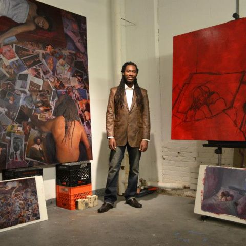 artist Arcmanoro Niles standing between paintings in studio