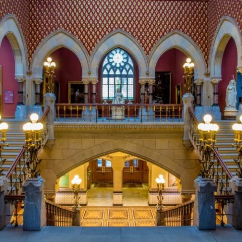 View of the grand and ornate staircase of the Historic Landmark Building. Looking down on the center staircase to the lobby, and up into the main gallery with a staircase on both the left and right sides of the image.  