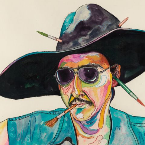 Man wearing hat and sunglasses with paintbrushes