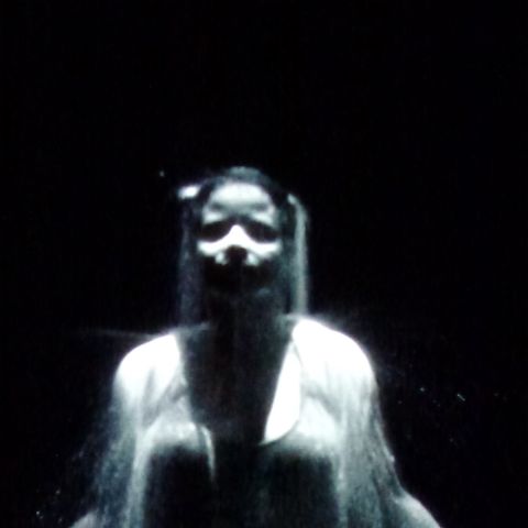 black and white video still of person under water