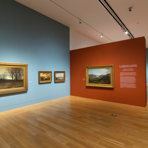 installation view of galleries with blue and red walls and landscape paintings