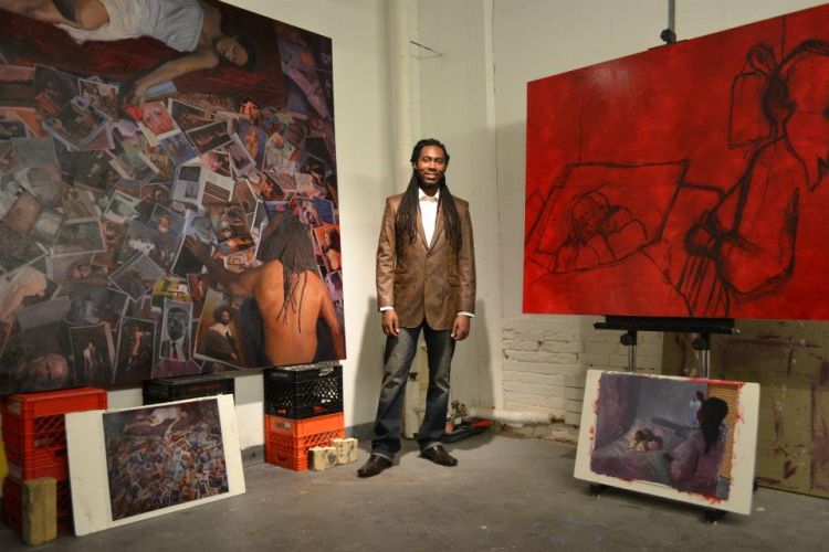 artist Arcmanoro Niles standing between paintings in studio