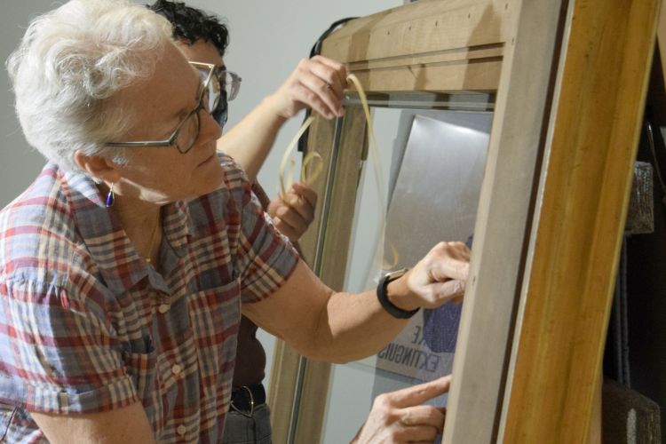 Conservators working on a frame