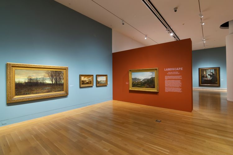 installation view of galleries with blue and red walls and landscape paintings