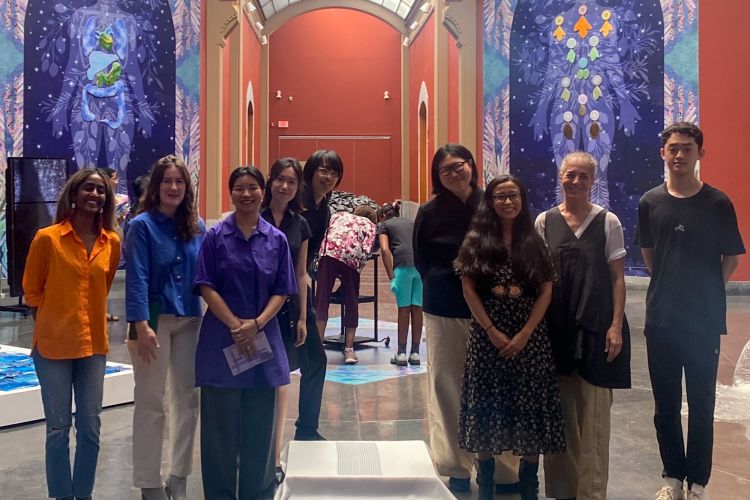 eight people smile in museum gallery six students and two teachers 