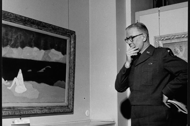 black and white photo of Gen. Lemuel Mathewson on left side of the frame, his left hand pensively placed on his chin, looking at "Bather" by Milton Avery, Berlin, 1951 