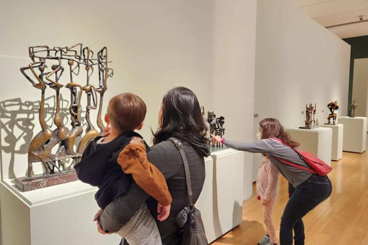 adults and children looking at sculpture
