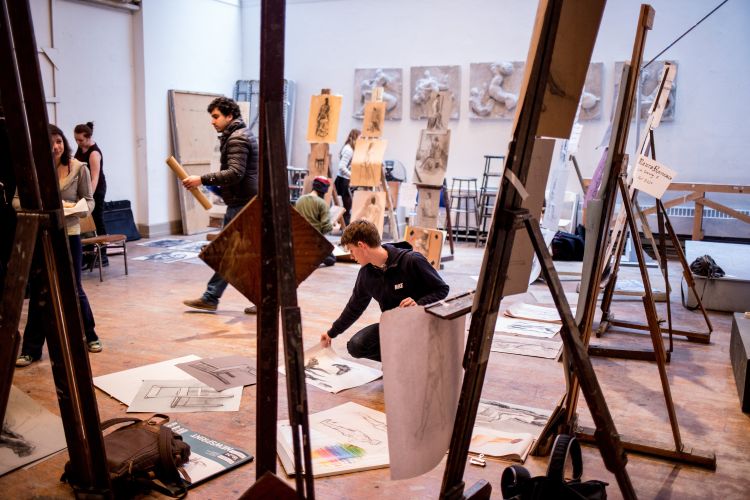 Student wit art laid out in front of them