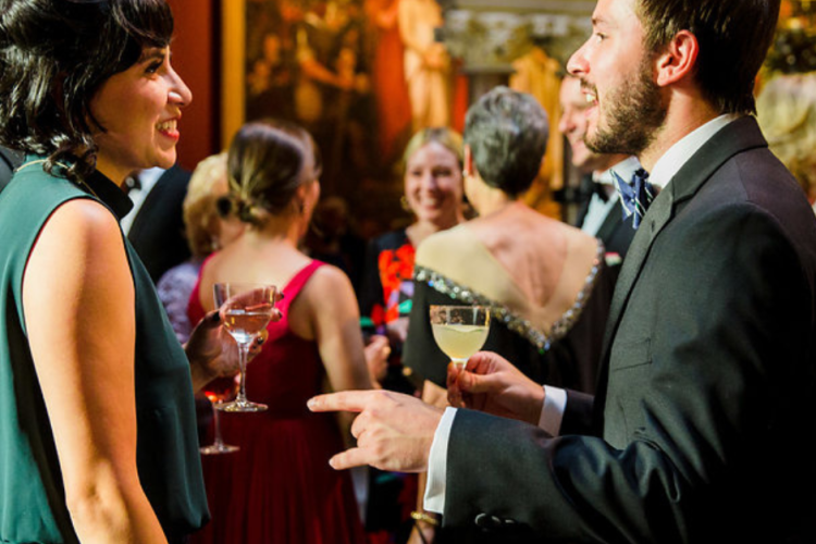 People standing in an art gallery talking.