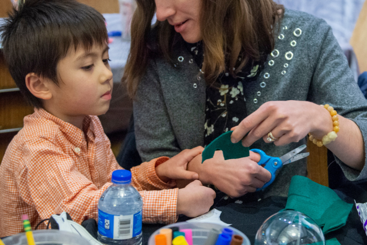 Parent helping child with art activity