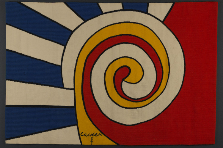 A vibrant, graphic Alexander Calder tapestry design featuring a prominent yellow, red, and white central spiral set against blue and white sunburst stripes on the left and a solid red field on the right.